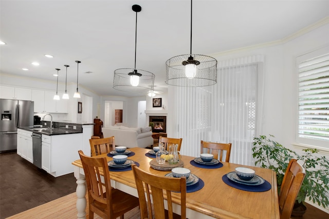 dining space featuring crown molding, sink, and dark hardwood / wood-style floors