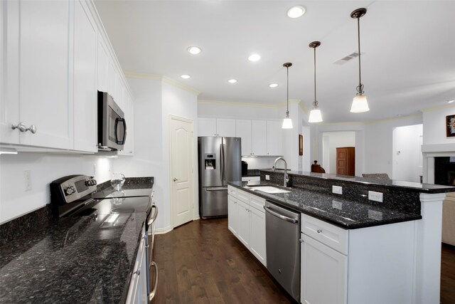 kitchen featuring white cabinets, decorative light fixtures, sink, and appliances with stainless steel finishes