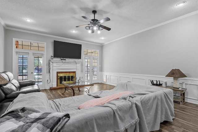 bedroom featuring french doors, ceiling fan, access to exterior, a textured ceiling, and a fireplace