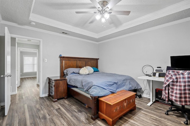 bedroom with ceiling fan, dark hardwood / wood-style flooring, a raised ceiling, and ornamental molding