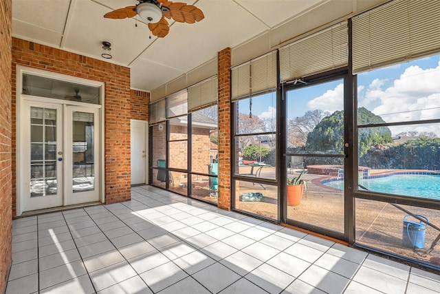 unfurnished sunroom with french doors and ceiling fan