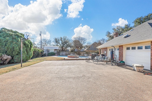 view of yard with a garage, a fenced in pool, and a patio