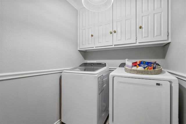 laundry room with separate washer and dryer and cabinets