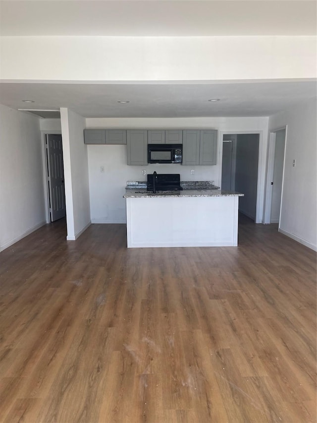 kitchen featuring gray cabinets, dark stone countertops, range, and dark wood-type flooring