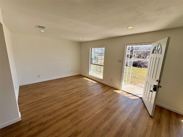 interior space featuring baseboards, visible vents, and wood finished floors