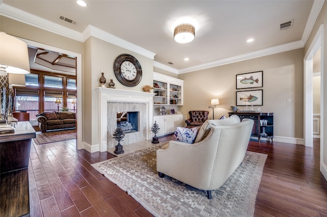 living area featuring crown molding, visible vents, dark wood-style flooring, and a high end fireplace