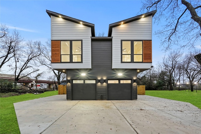 property exterior at dusk featuring a lawn and a garage