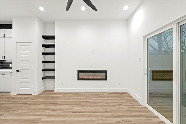 unfurnished living room with light wood-type flooring and ceiling fan