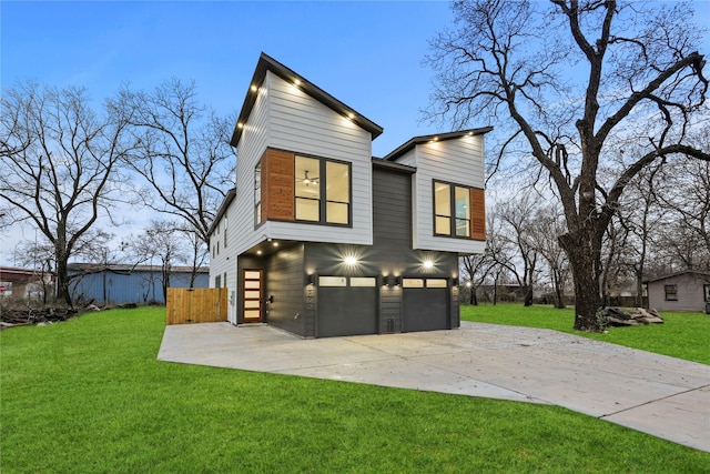 back house at dusk featuring a garage and a yard