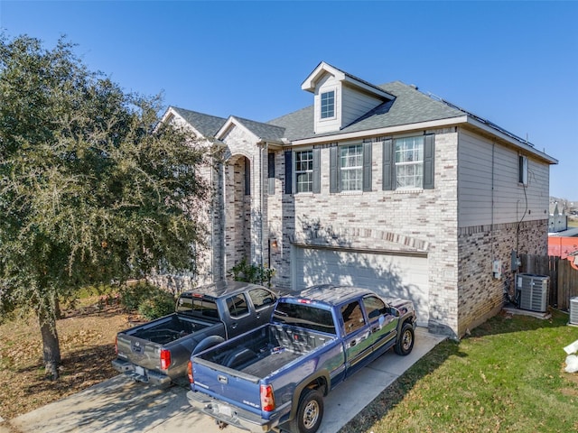 view of front facade featuring a garage and central AC unit