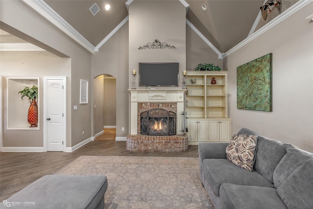 living room with ornamental molding, a fireplace, high vaulted ceiling, and wood-type flooring