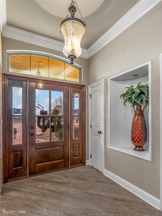 entrance foyer with hardwood / wood-style flooring, ornamental molding, and a notable chandelier