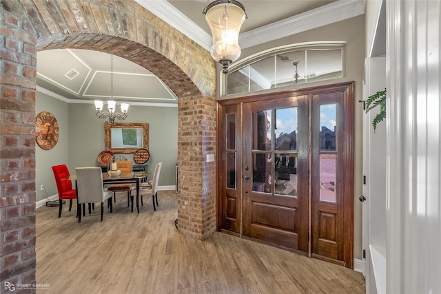 foyer featuring ornamental molding, a chandelier, and light hardwood / wood-style floors