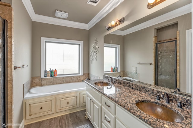 bathroom featuring independent shower and bath, ornamental molding, hardwood / wood-style flooring, and vanity