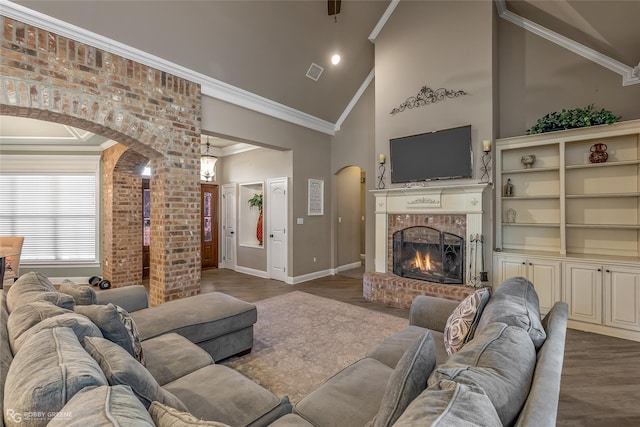 living room featuring ornamental molding, a brick fireplace, dark wood-type flooring, and high vaulted ceiling