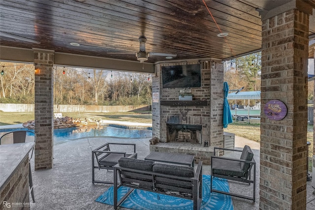 view of patio / terrace with an outdoor brick fireplace, ceiling fan, and a fenced in pool