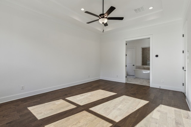 unfurnished bedroom featuring connected bathroom, dark hardwood / wood-style floors, a raised ceiling, and ceiling fan