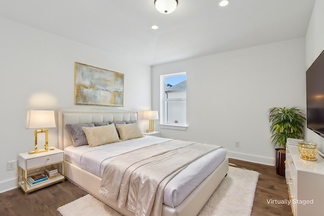 bedroom with dark hardwood / wood-style flooring