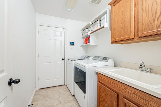 laundry room featuring sink, light tile patterned flooring, cabinets, and independent washer and dryer