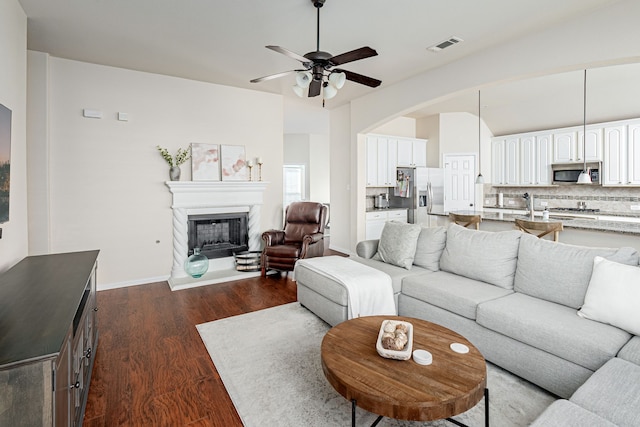 living room featuring ceiling fan and dark hardwood / wood-style floors