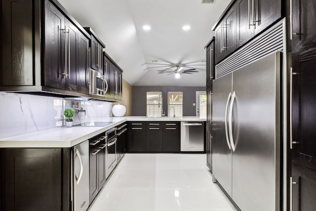 kitchen featuring vaulted ceiling, ceiling fan, tasteful backsplash, kitchen peninsula, and stainless steel appliances