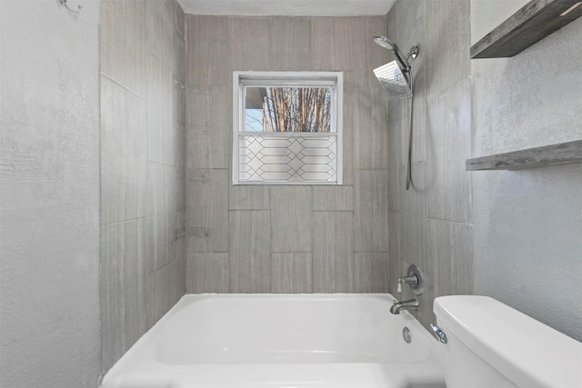 bathroom with tiled shower / bath and toilet