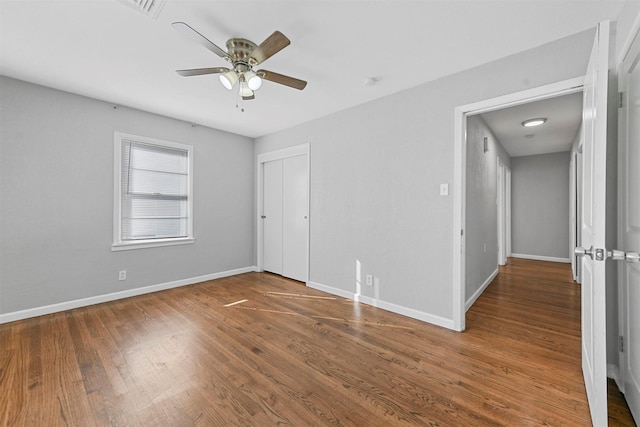 unfurnished bedroom with hardwood / wood-style floors, ceiling fan, and a closet