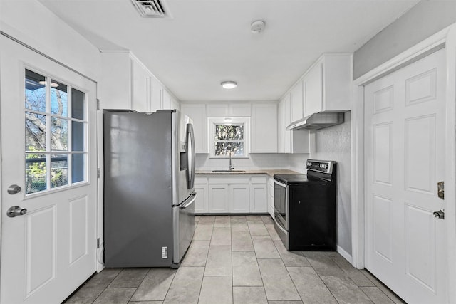 kitchen featuring decorative backsplash, appliances with stainless steel finishes, sink, light tile patterned floors, and white cabinets