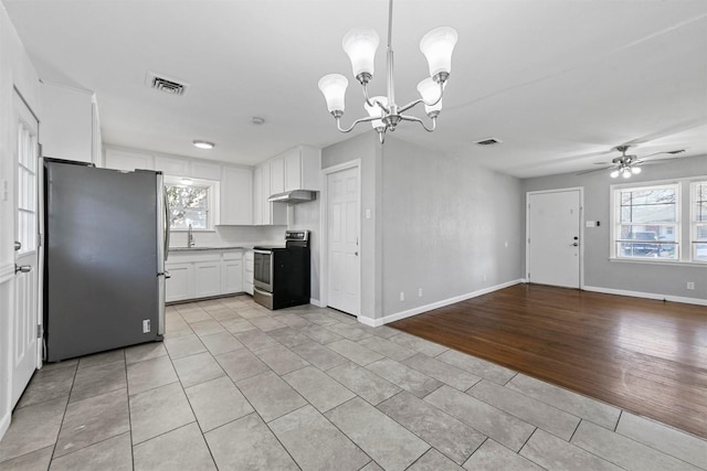 kitchen featuring sink, pendant lighting, stainless steel appliances, ceiling fan with notable chandelier, and white cabinets