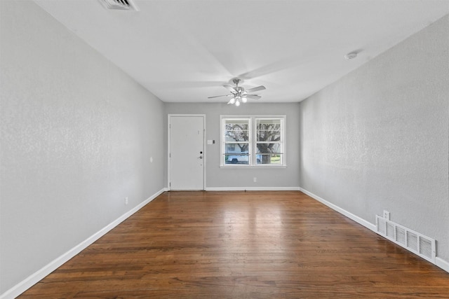 spare room featuring dark wood-type flooring and ceiling fan