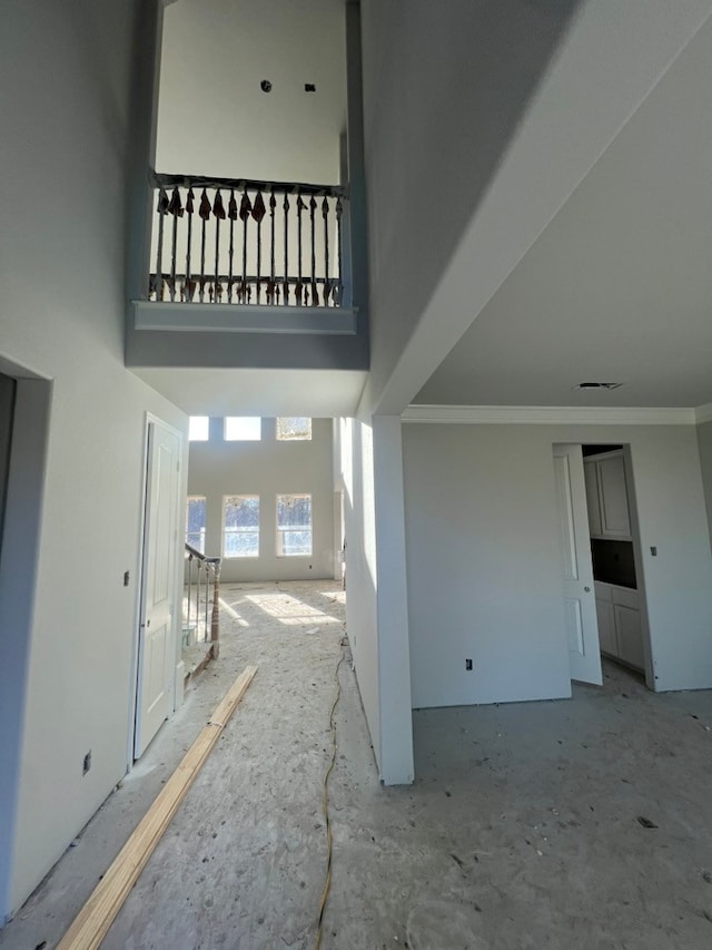 interior space with crown molding and a high ceiling