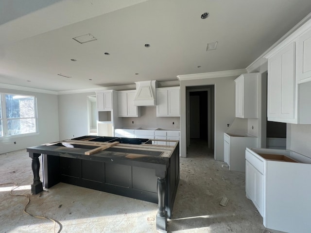 kitchen with custom exhaust hood, white cabinetry, a kitchen island, and crown molding