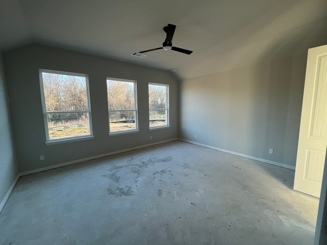 spare room with concrete floors, visible vents, vaulted ceiling, and baseboards