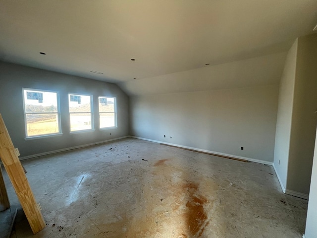 unfurnished room featuring lofted ceiling