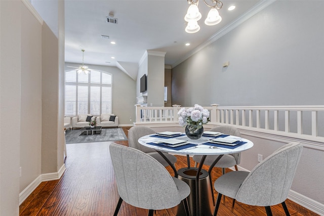 dining space featuring ceiling fan with notable chandelier, hardwood / wood-style flooring, and crown molding