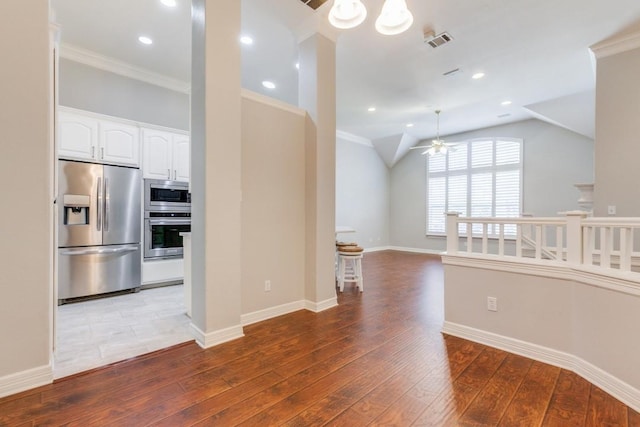 interior space featuring ceiling fan, light wood-type flooring, vaulted ceiling, and crown molding