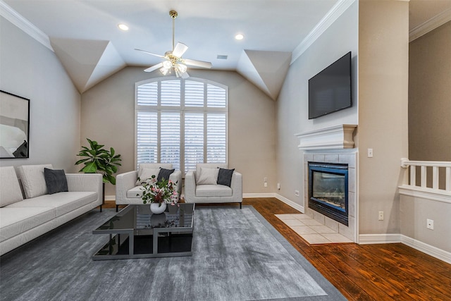 living room featuring hardwood / wood-style flooring, ceiling fan, ornamental molding, and a fireplace