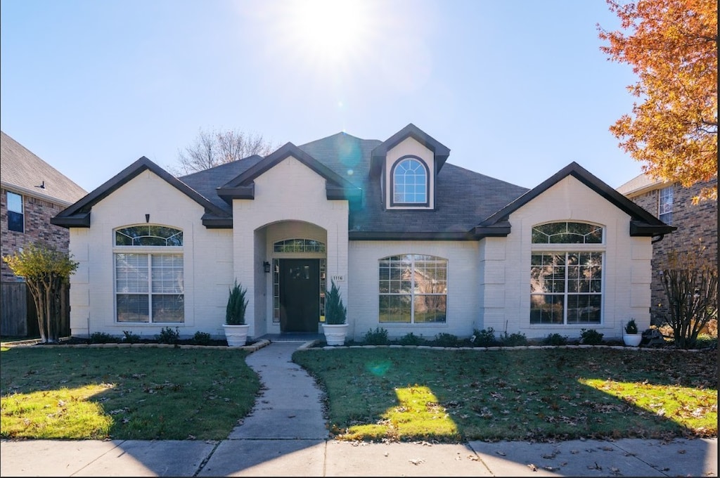 french provincial home with a front lawn