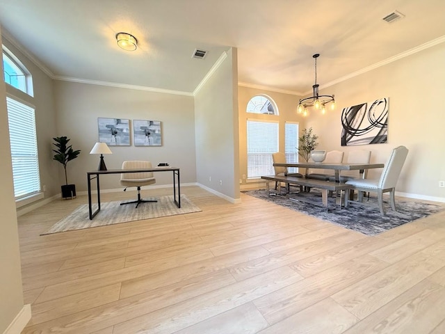 dining space with a notable chandelier, ornamental molding, and light hardwood / wood-style flooring