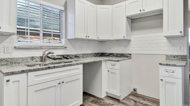 kitchen featuring white cabinets, light stone counters, dark wood-type flooring, and sink