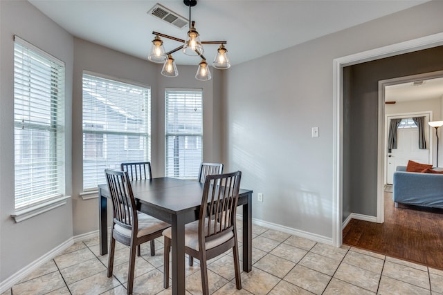 tiled dining room featuring an inviting chandelier