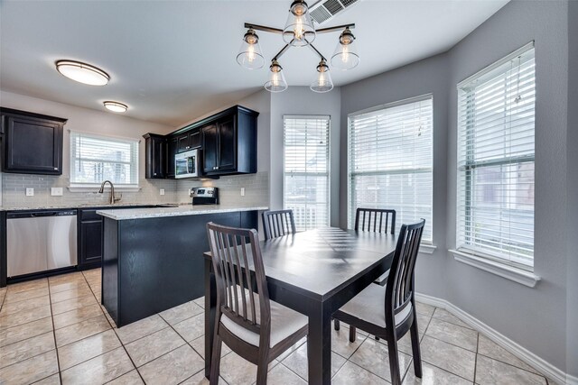 dining space featuring a chandelier, light tile patterned floors, and a healthy amount of sunlight