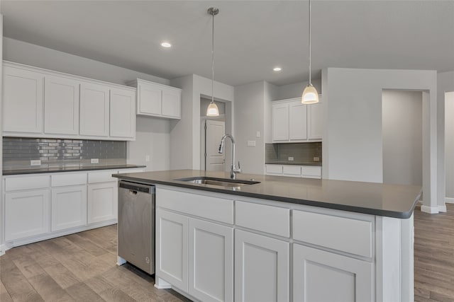 kitchen featuring pendant lighting, a center island with sink, sink, stainless steel dishwasher, and white cabinetry