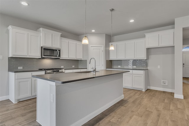 kitchen with white cabinets, stove, and sink