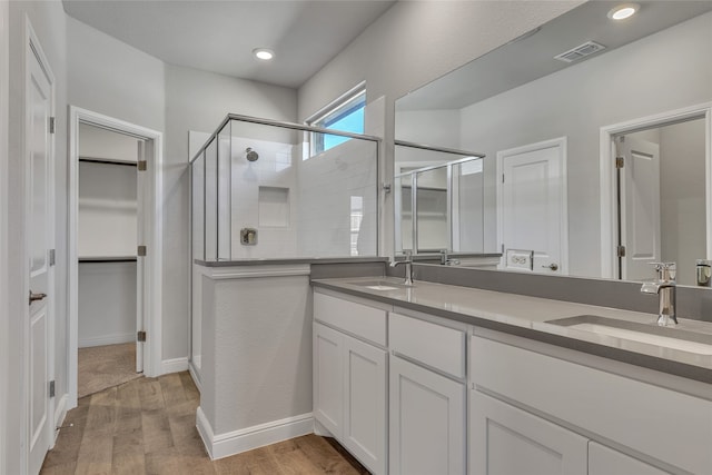 bathroom featuring hardwood / wood-style flooring, vanity, and an enclosed shower