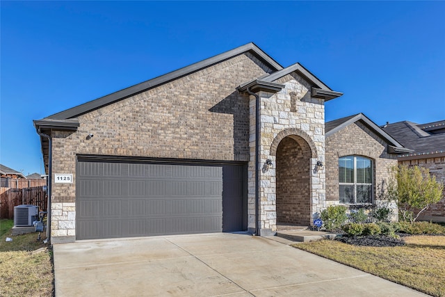 view of front of property featuring cooling unit and a garage