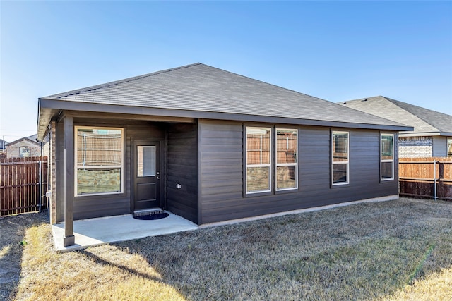 back of property featuring a patio area and a yard