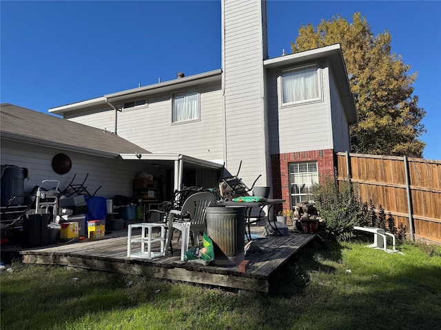 rear view of house with a lawn and a wooden deck