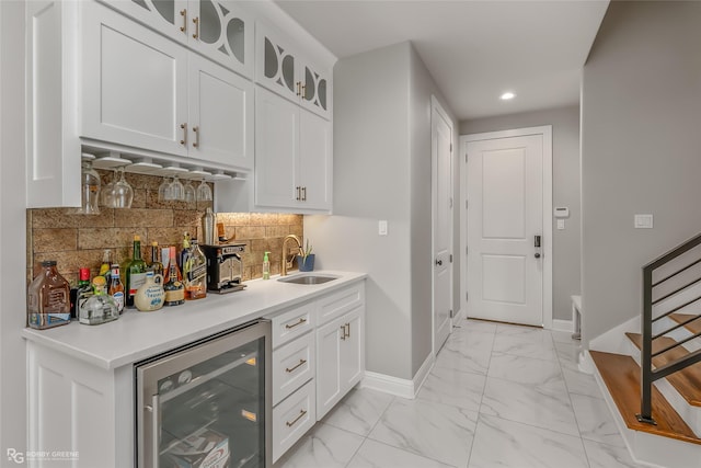 bar featuring white cabinets, tasteful backsplash, sink, and wine cooler