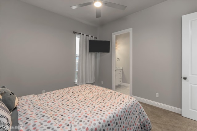 bedroom featuring light carpet, connected bathroom, and ceiling fan